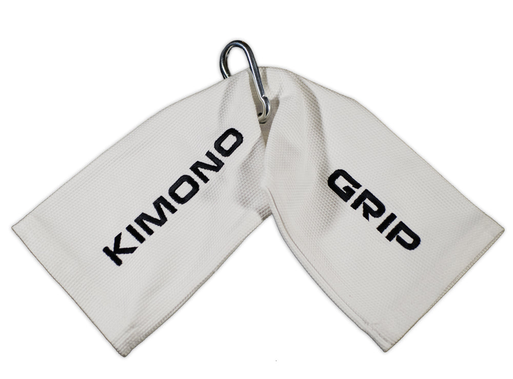 Kimono Grip: two white gi fabric tails on one carabiner, KIMONO and GRIP embroidered